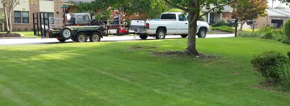 QuickCall Services truck and lawn equipment beside a recently mowed lawn in Grovetown